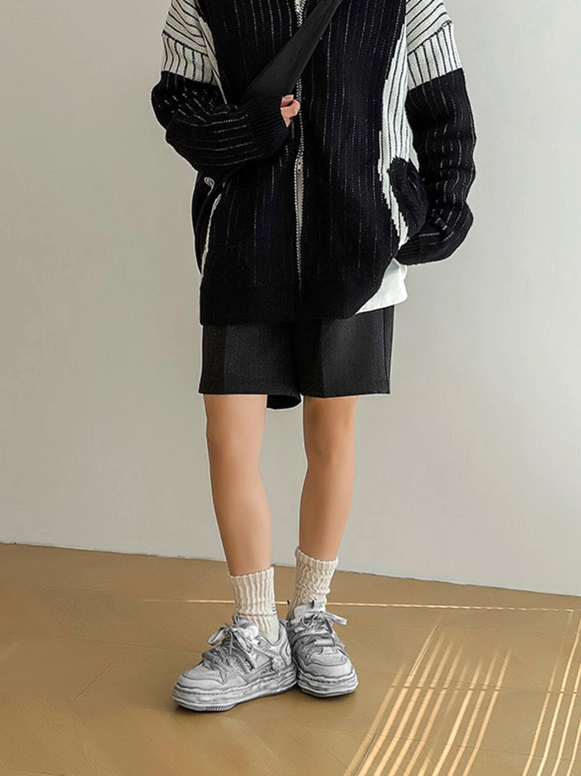Washed gray platform sneakers styled with black shorts and a striped knit sweater for a relaxed Korean streetwear outfit