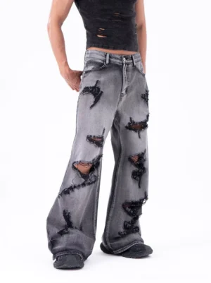Front three-quarter view of washed gray shredded wide-leg jeans with heavy frayed rips and relaxed Korean streetwear styling