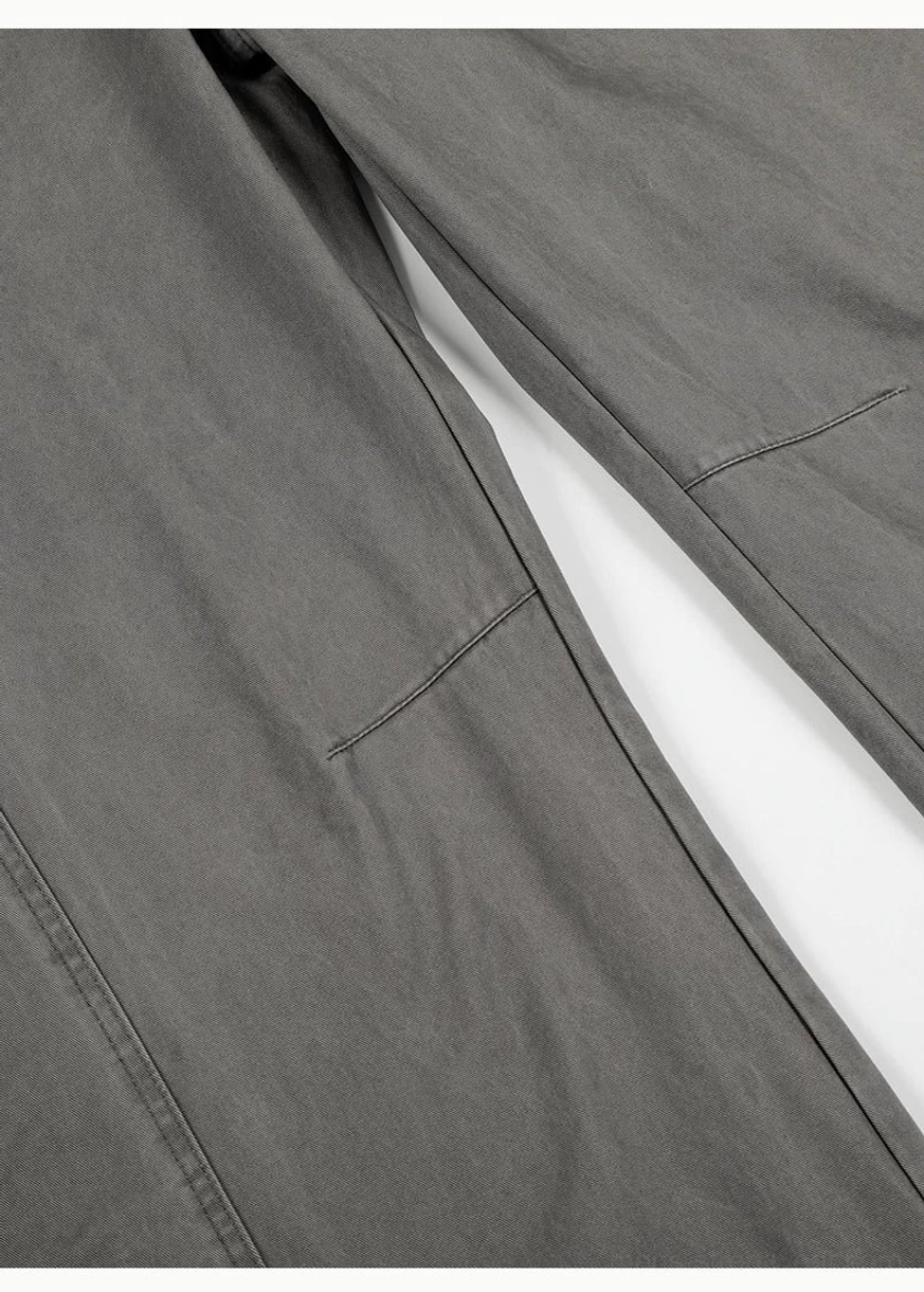 Close-up of curved panel seam construction on washed grey barrel leg cotton twill chino pants