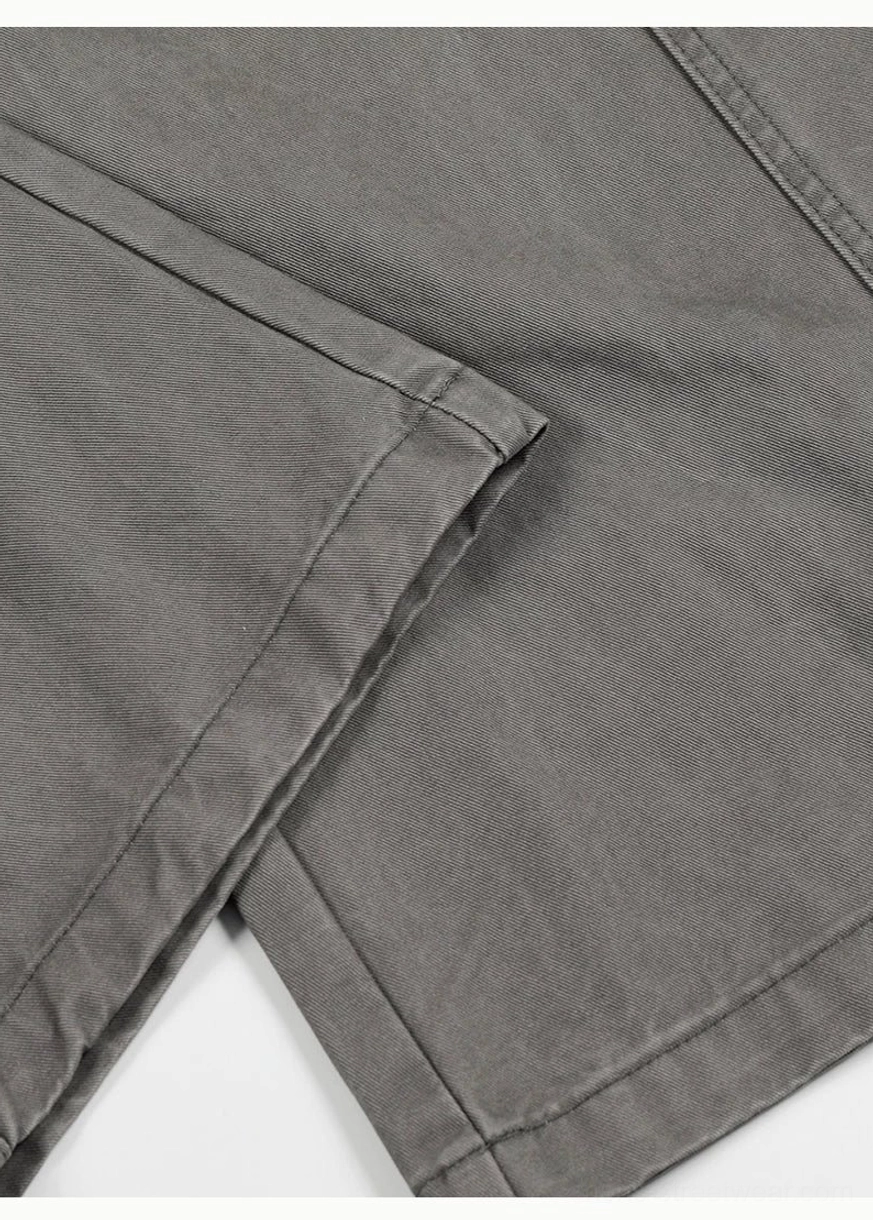 Side hem close-up of washed grey barrel leg chino pants showing clean finished edge and precise seam stitching