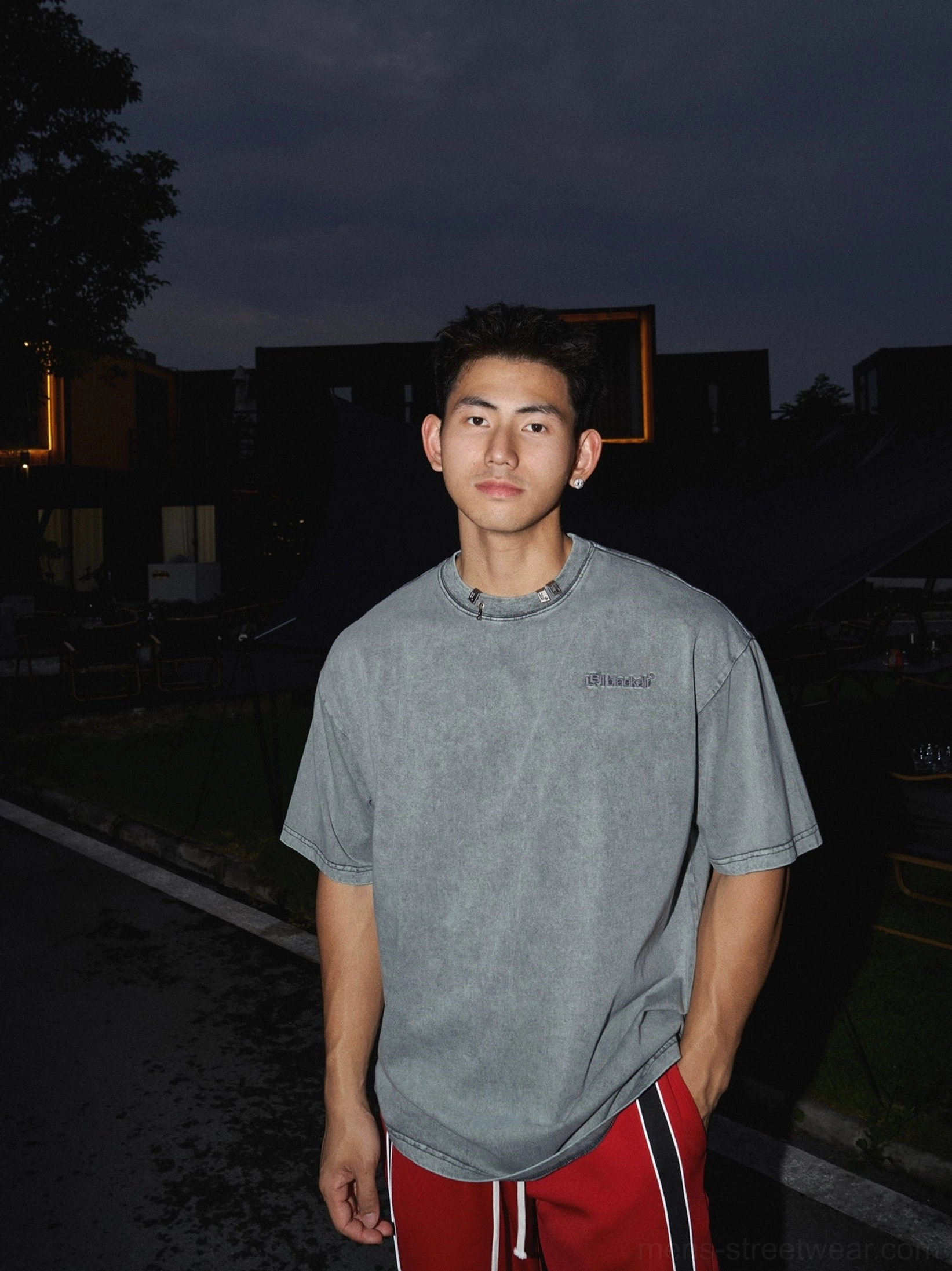 Washed grey cotton oversized T-shirt with subtle chest lettering paired with red side-stripe track pants in a relaxed Seoul streetwear outfit