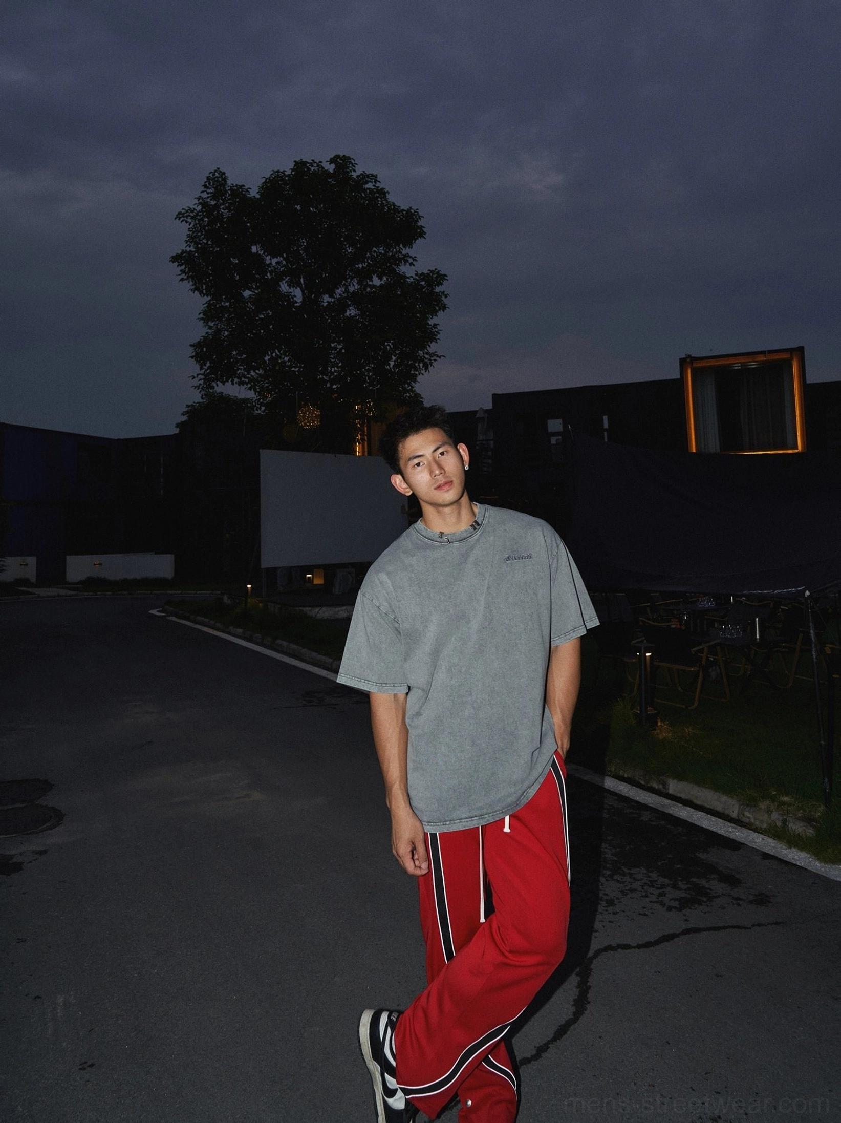 Full rear view of a washed grey cotton oversized T-shirt with loose relaxed fit styled with red track pants in an urban streetwear outfit