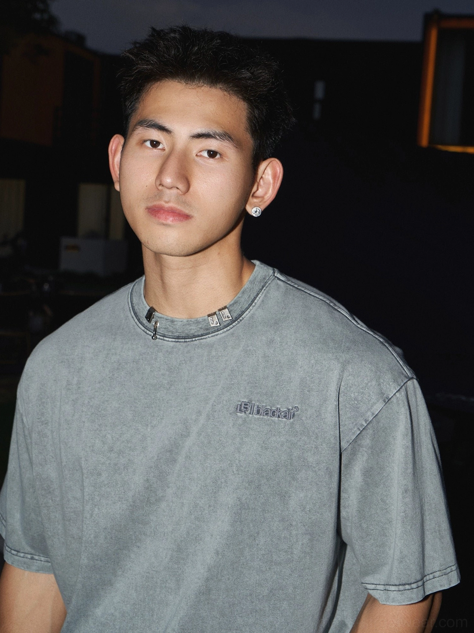 Washed grey cotton oversized T-shirt close-up with faded finish, ribbed crew neck, subtle chest lettering, and modern Korean styling