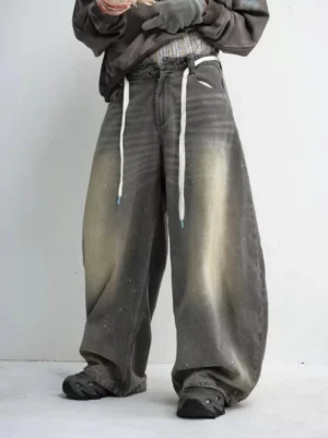 Front view of washed grey drawstring paint-splatter wide leg jeans with an oversized baggy denim silhouette