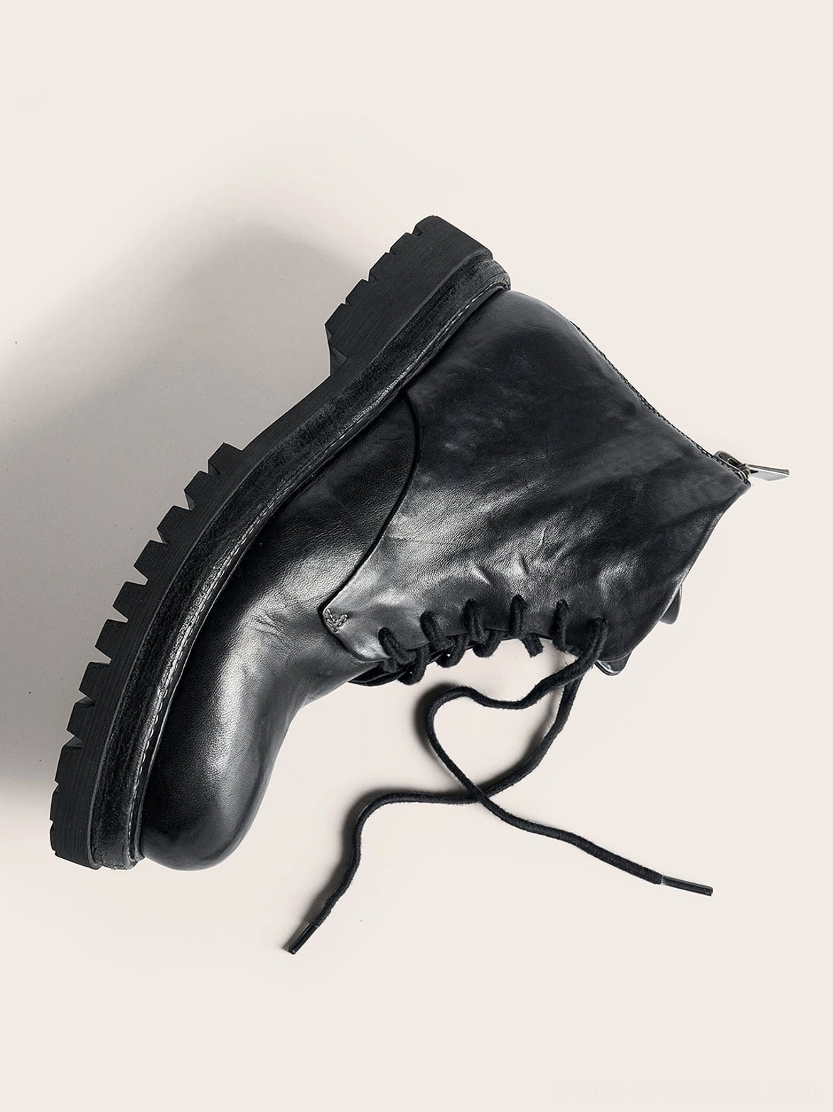 Black washed horsehide combat boot with loose laces and deep lugged rubber outsole detail