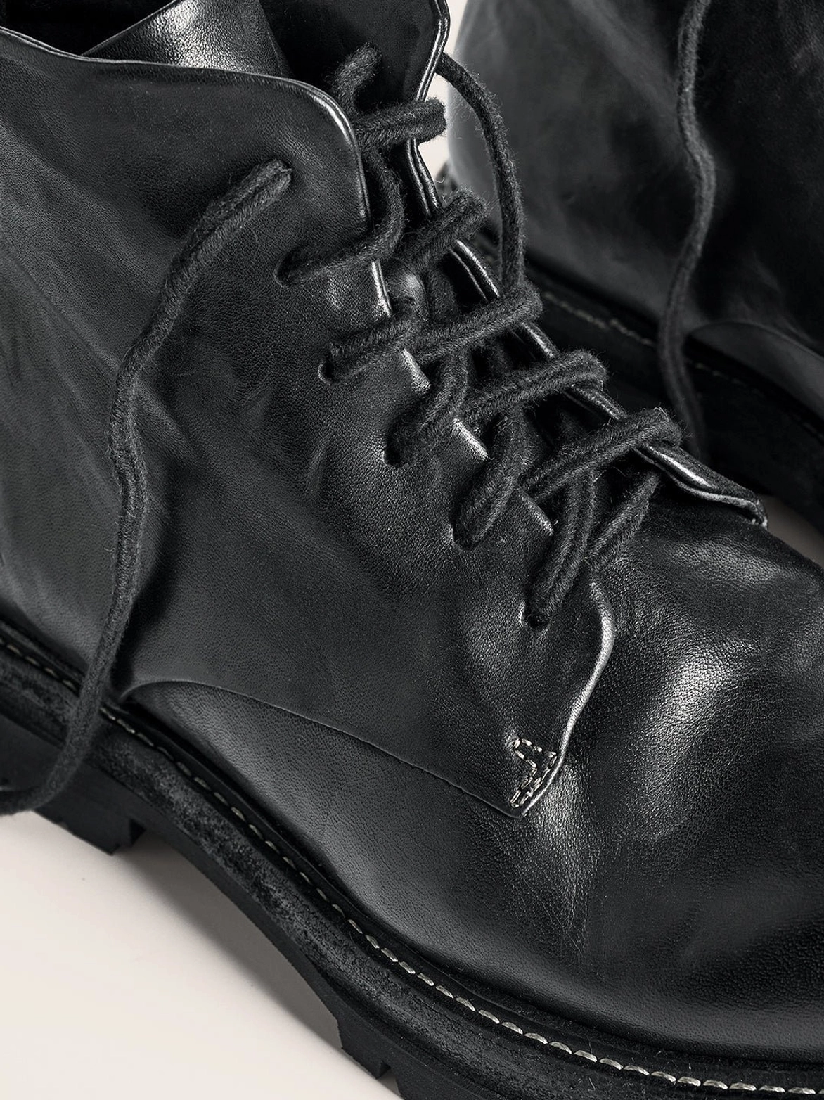 Black washed horsehide rear-zip combat boots with round toe stitched welt and chunky rubber lug sole