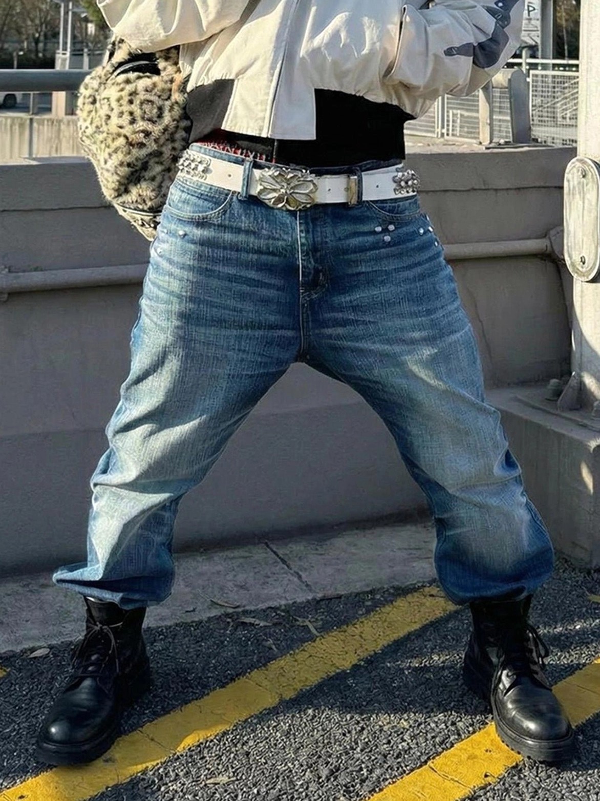 Black washed horsehide combat boots styled with faded jeans ornate silver belt and leopard print crossbody bag