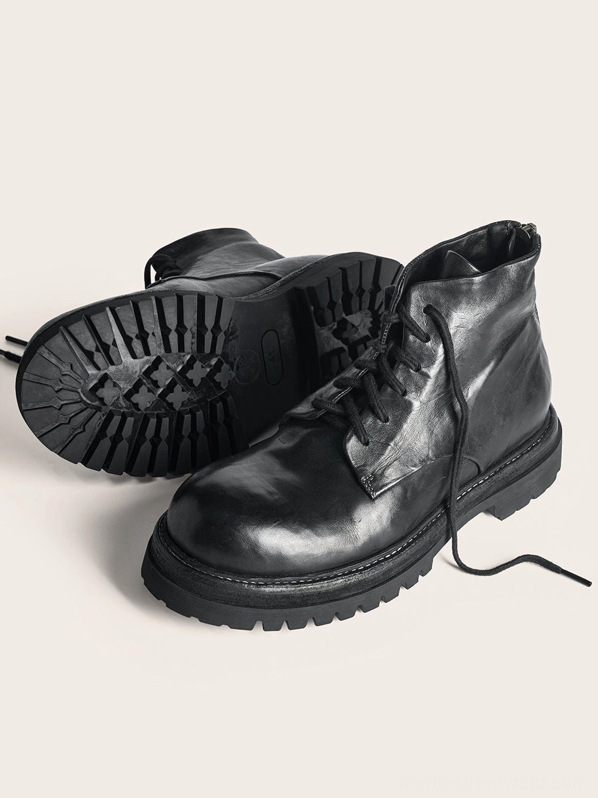 Top view of black washed horsehide rear-zip combat boots showing polished leather uppers laces and outsole tread