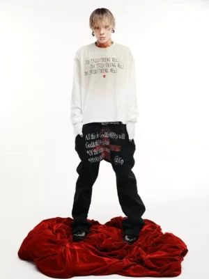 Washed ivory distressed slogan graphic long sleeve tee front view worn with black streetwear pants