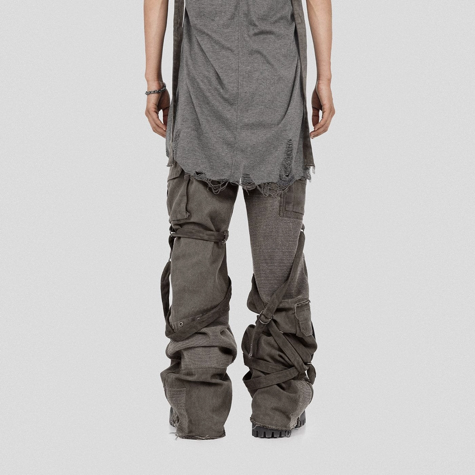 Back view of washed tactical cargo pants featuring rear leg straps multiple utility pockets and stacked wide legs