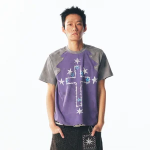 Front view of a washed purple cross graphic raglan T-shirt with grey sleeves, star accents, shoulder rivets, and distressed streetwear print