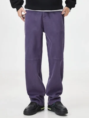 Front view of washed relaxed wide-leg streetwear pants with knee panel stitching and side pockets styled with a layered black sweatshirt and sneakers