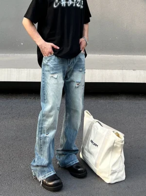 Close front view of light blue washed distressed wide-leg jeans with ripped details and raw frayed cuffs