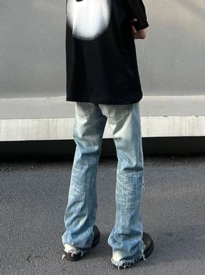 Rear view of washed blue distressed wide-leg skater jeans with long frayed hems on an urban street