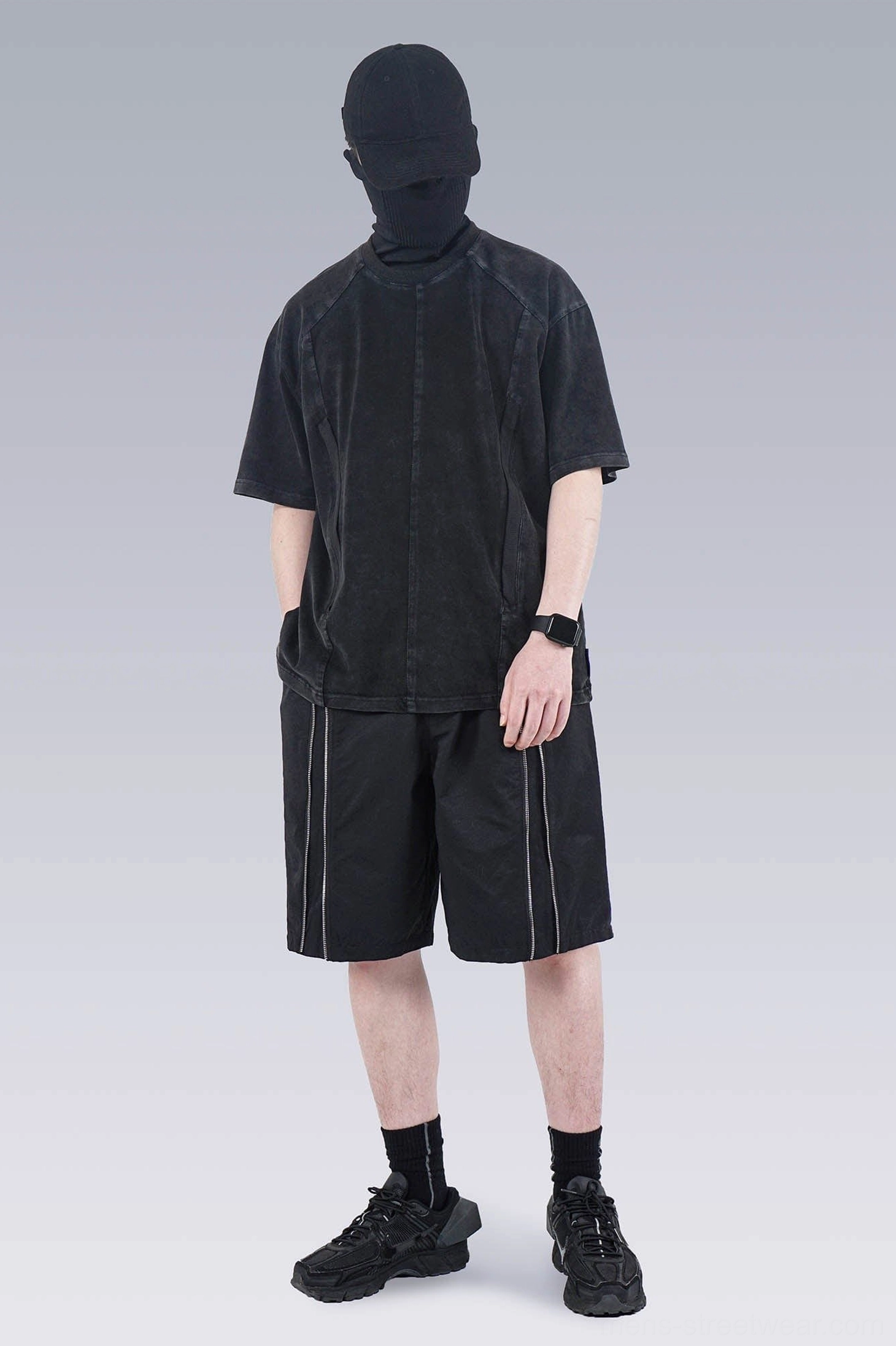 Faded black washed technical oversized T-shirt styled with black track shorts for a modern streetwear outfit