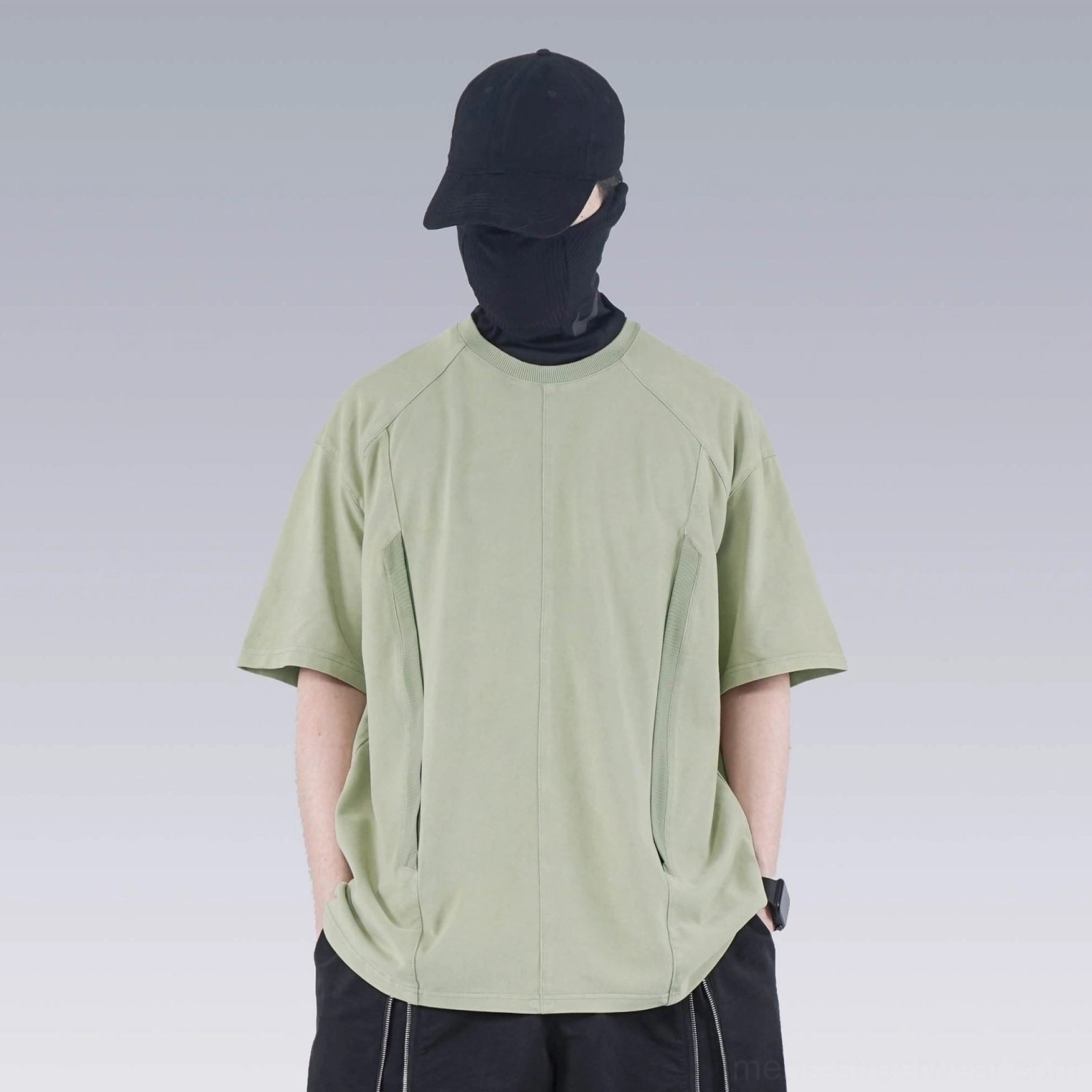 Front view of sage green washed technical oversized T-shirt with raglan sleeves and hidden side pockets