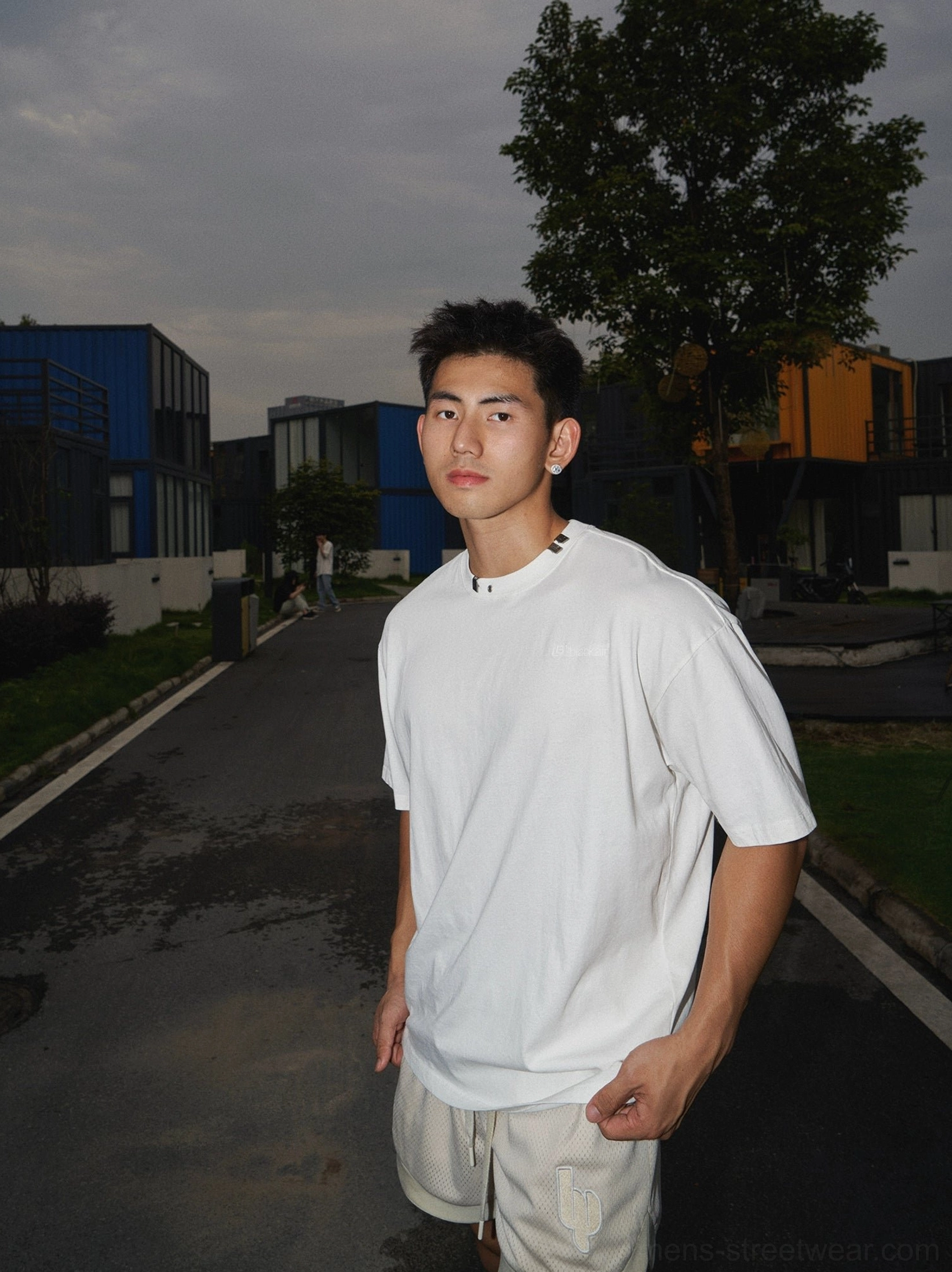 Washed white cotton oversized T-shirt with subtle chest print and relaxed crew neck worn in a modern Korean streetwear outfit
