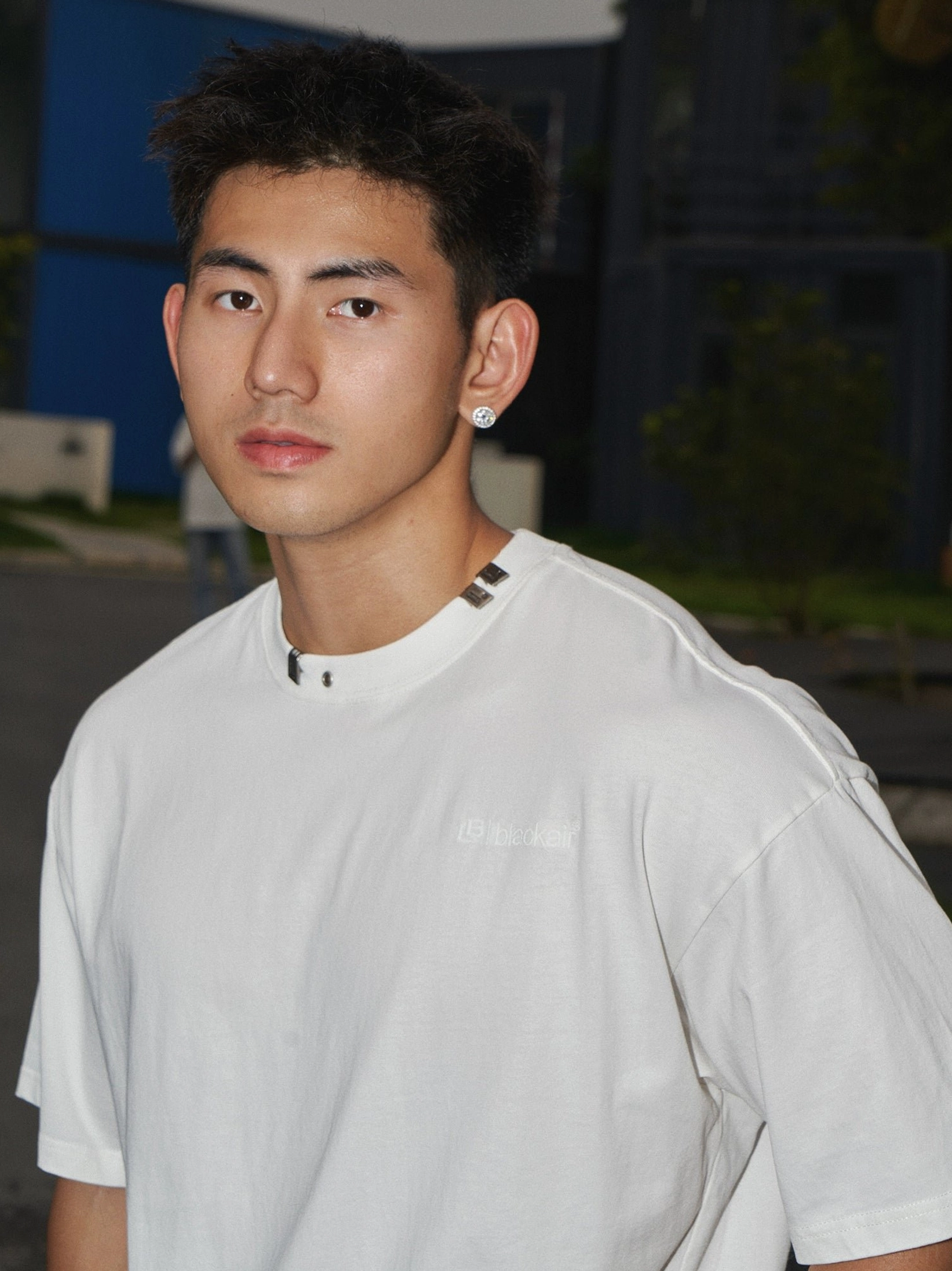 Washed white cotton oversized T-shirt with subtle chest print, modified crew neck metal trim, and contemporary East Asian streetwear styling