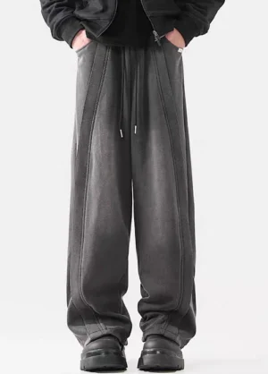 Front view of washed dark gray wide-leg drawstring pants styled with black streetwear shoes