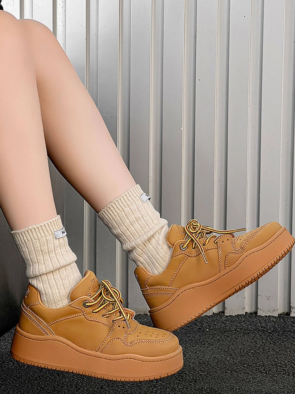 Wheat brown chunky platform sneaker worn with beige crew socks in a side three-quarter streetwear outfit