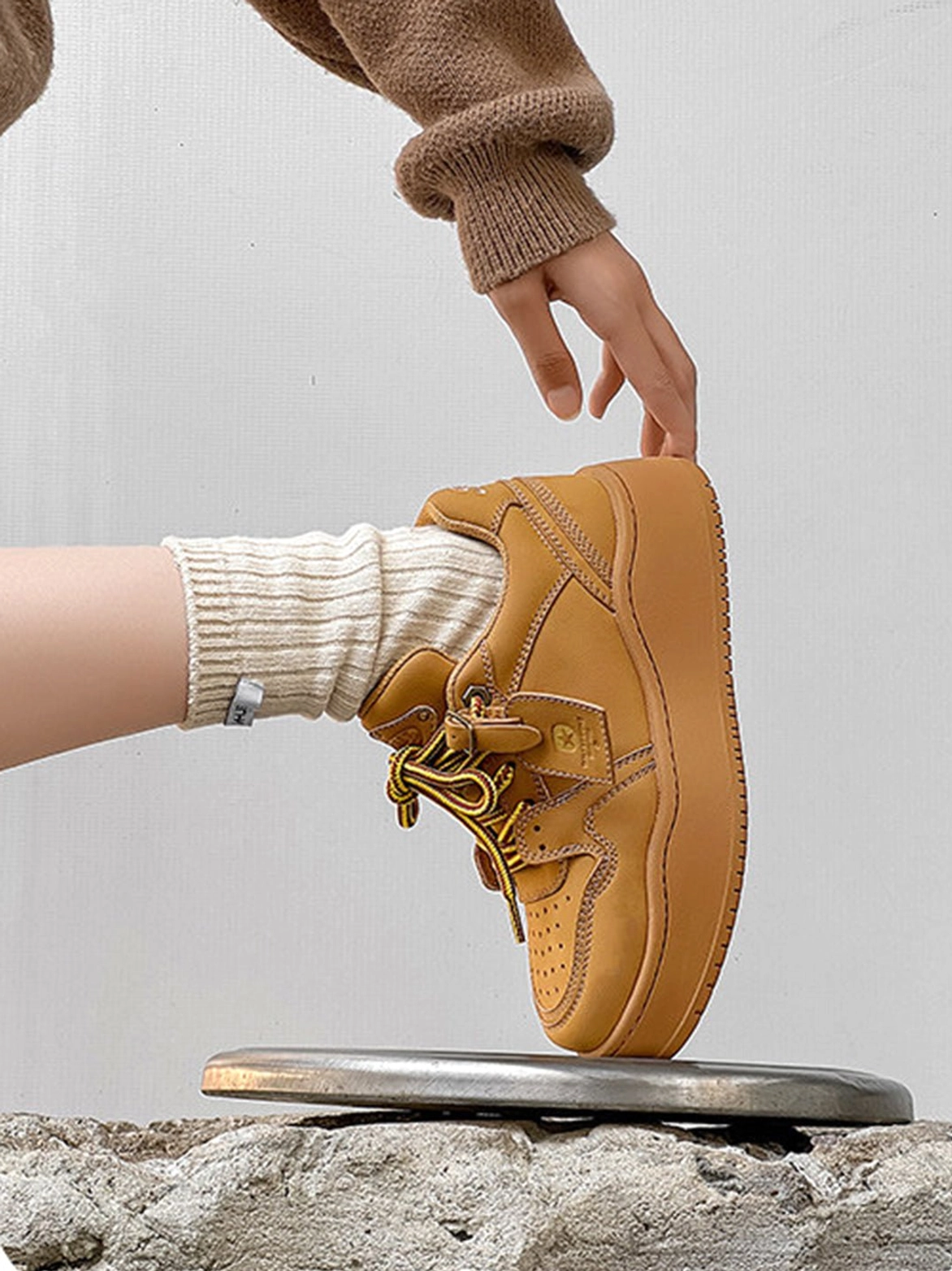 Wheat brown chunky platform sneaker close-up showing stitched upper, branded tongue tag, and thick platform midsole