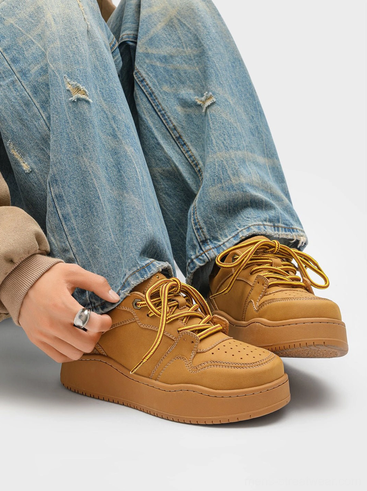Close-up front view of wheat brown platform sneakers with perforated toe cap, matching laces, and durable rubber outsole