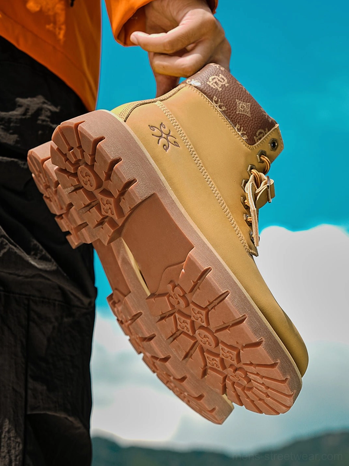Bottom-up view of wheat streetwear work boots highlighting the deep tread lug sole, side lace details, padded collar, and rugged utility design