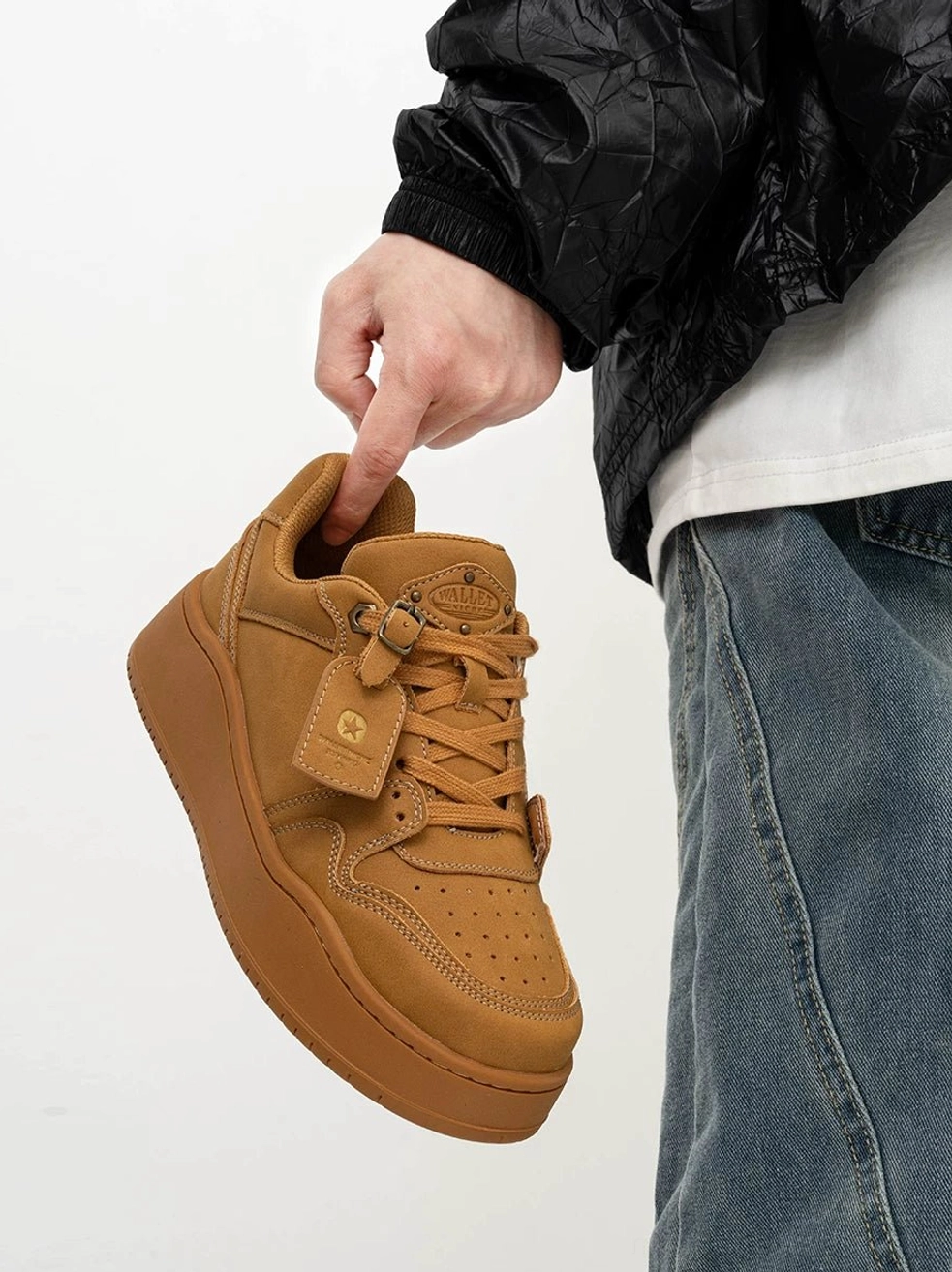 Wheat-toned low-top suede platform skate sneaker held from the side showing the tonal sole, rounded toe and relaxed Korean streetwear styling