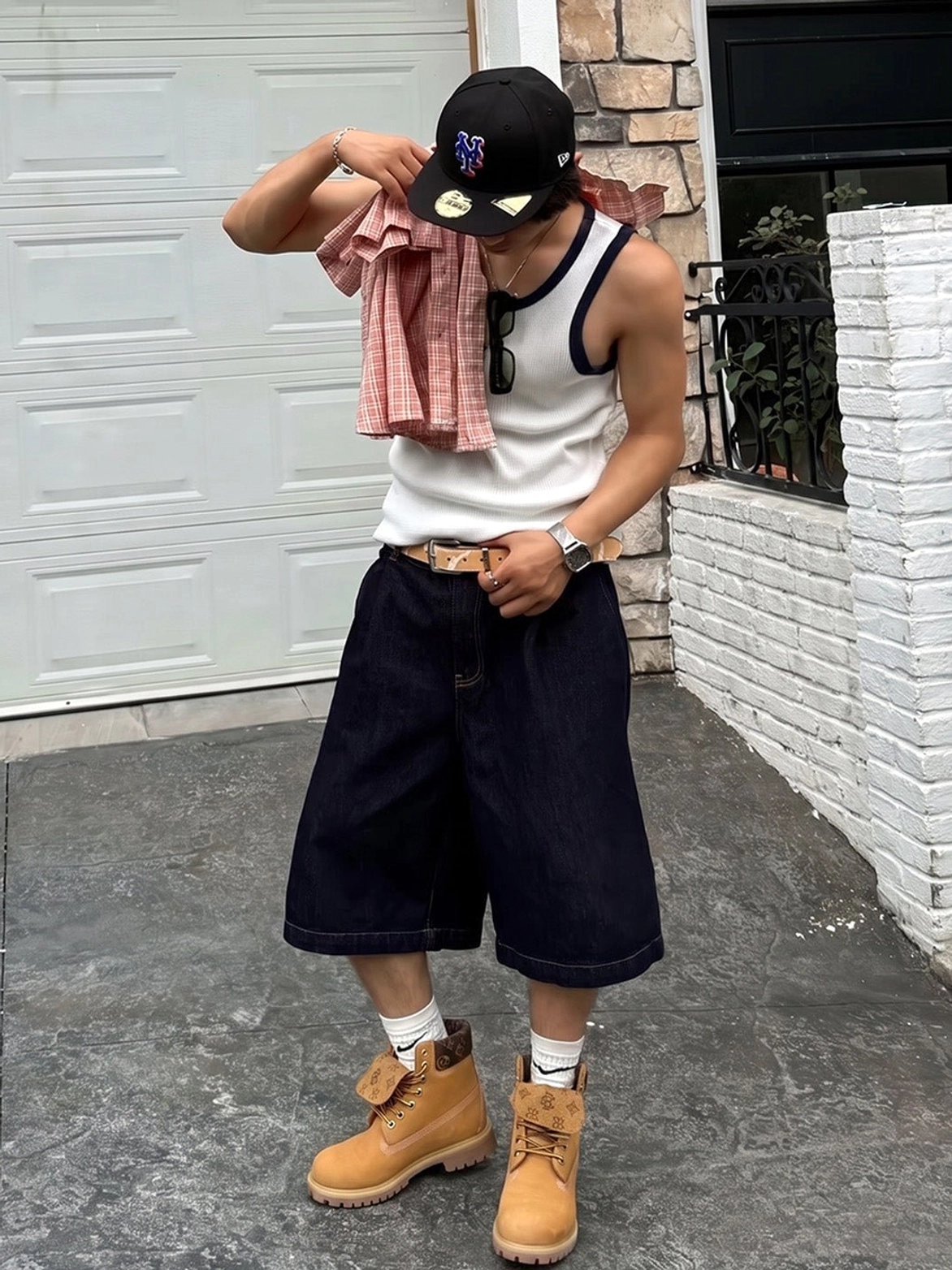 Front view of wheat yellow lace-up work boots styled with white socks, wide-leg shorts, and a relaxed urban streetwear outfit