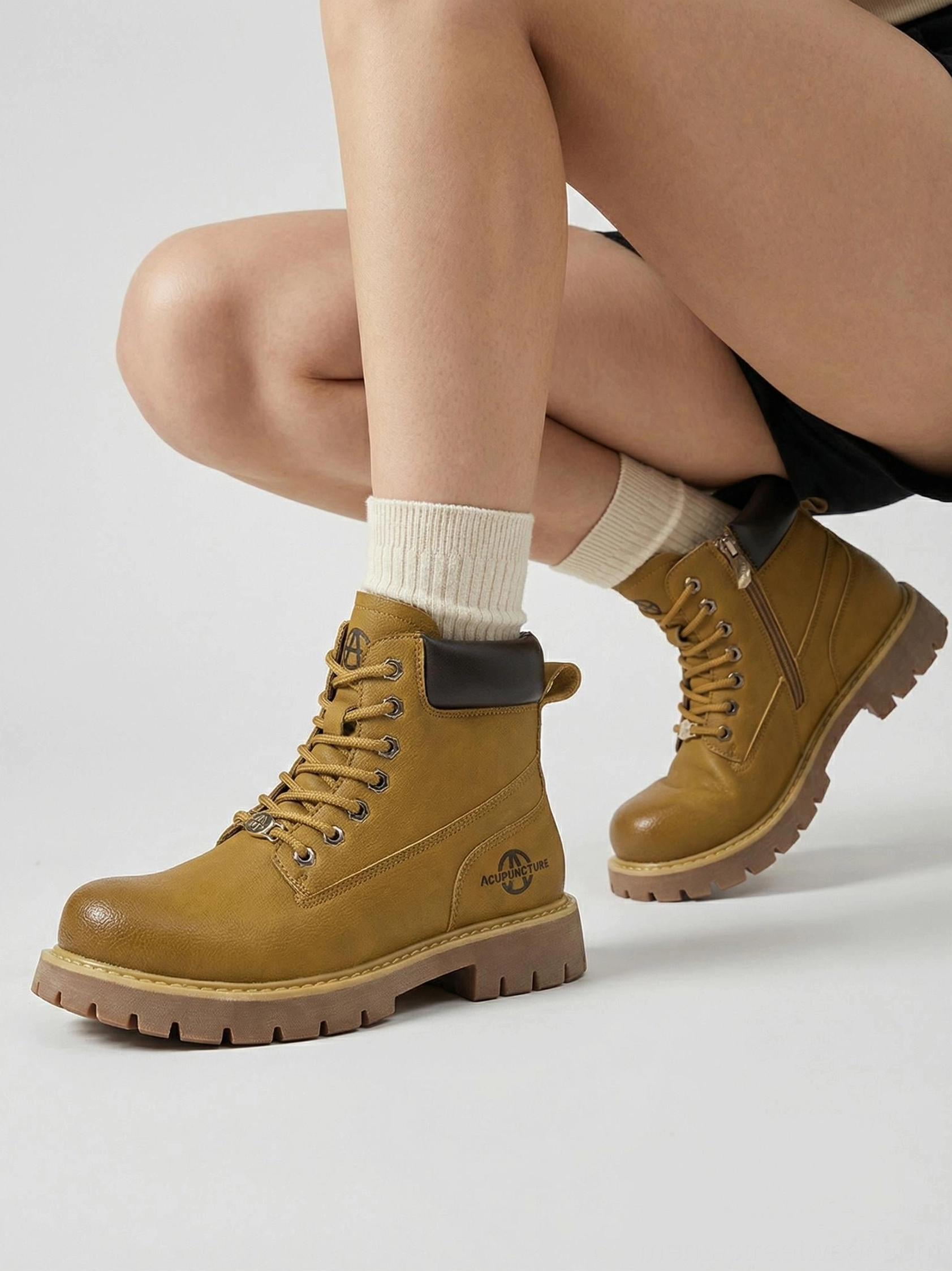 Wheat yellow lug sole ankle boots worn with white crew socks in a modern urban workwear outfit