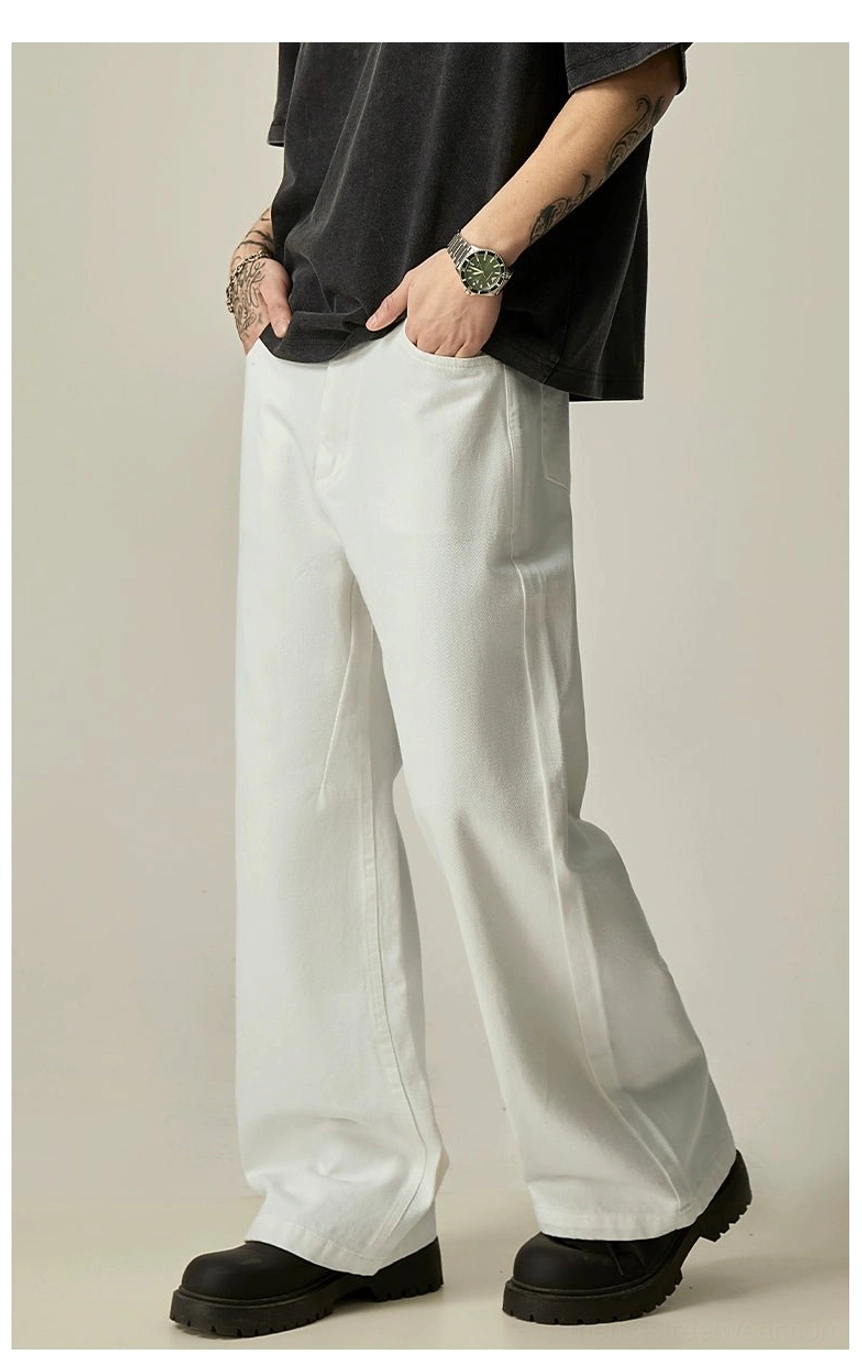 Side profile of white baggy wide-leg jeans with hand in pocket and clean Seoul fashion silhouette