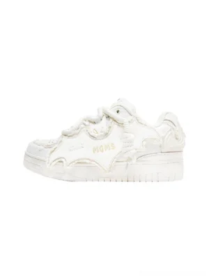 White bat-wing platform sneakers shown from the left side with distressed split-leather panels, frayed edge details, oversized rope laces, embroidered accents, and chunky streetwear sole