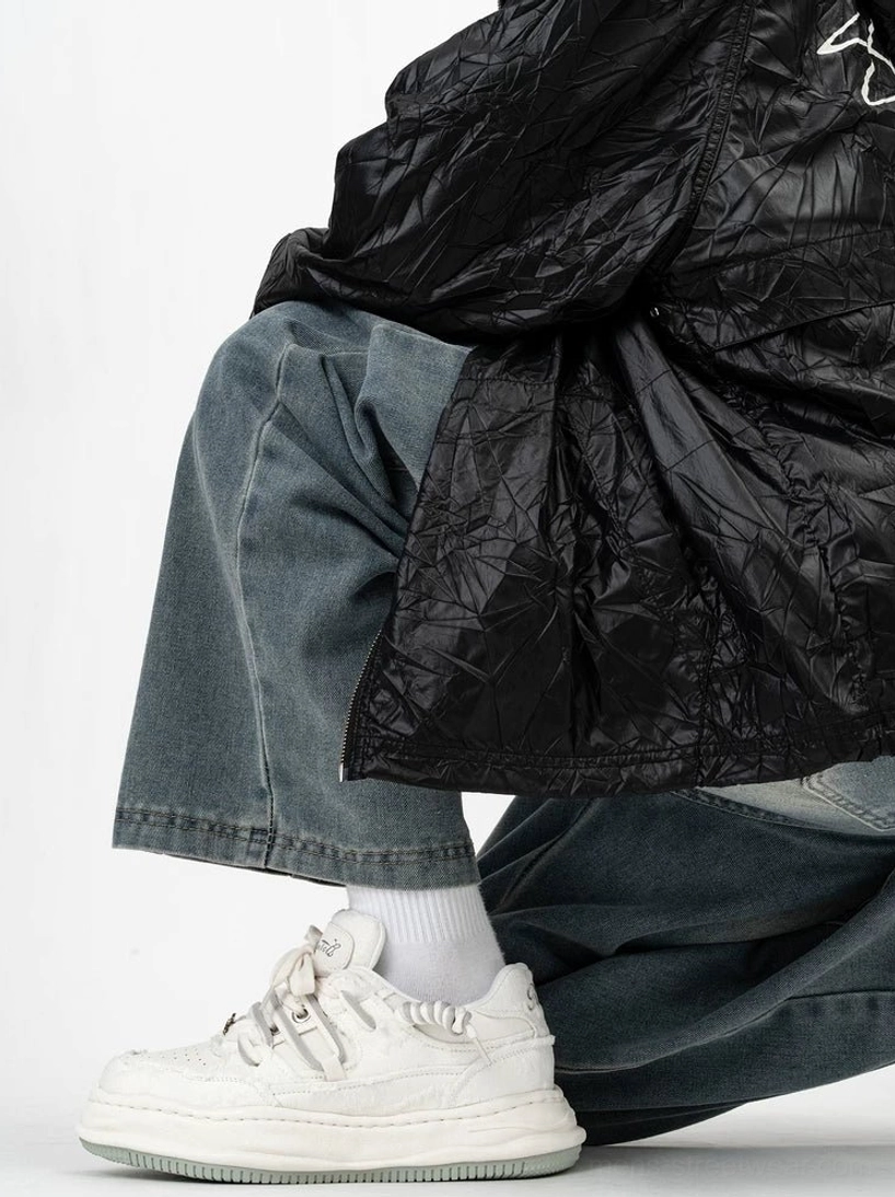 White chunky distressed streetwear sneakers worn with baggy jeans and white crew socks, featuring thick platform midsoles and decorative lace charm