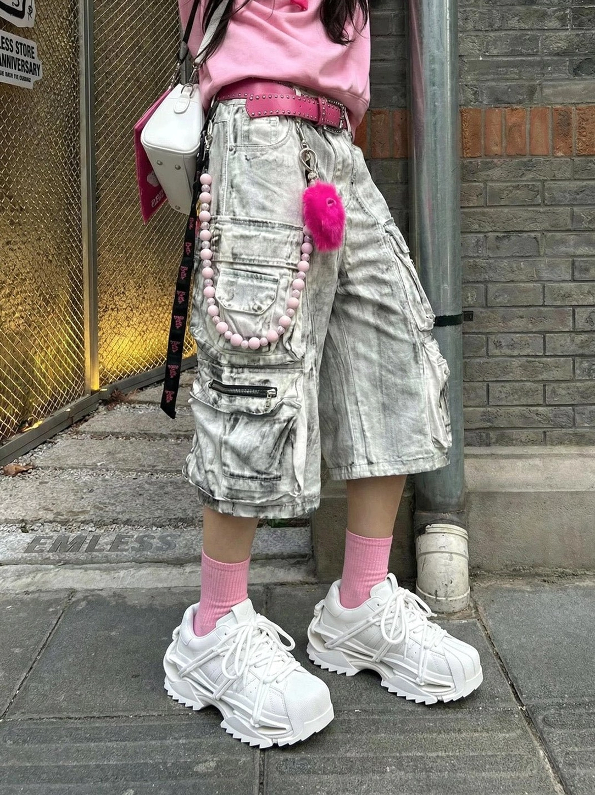 White chunky futuristic sneakers styled with pink socks and grey cargo shorts for an East Asian streetwear look