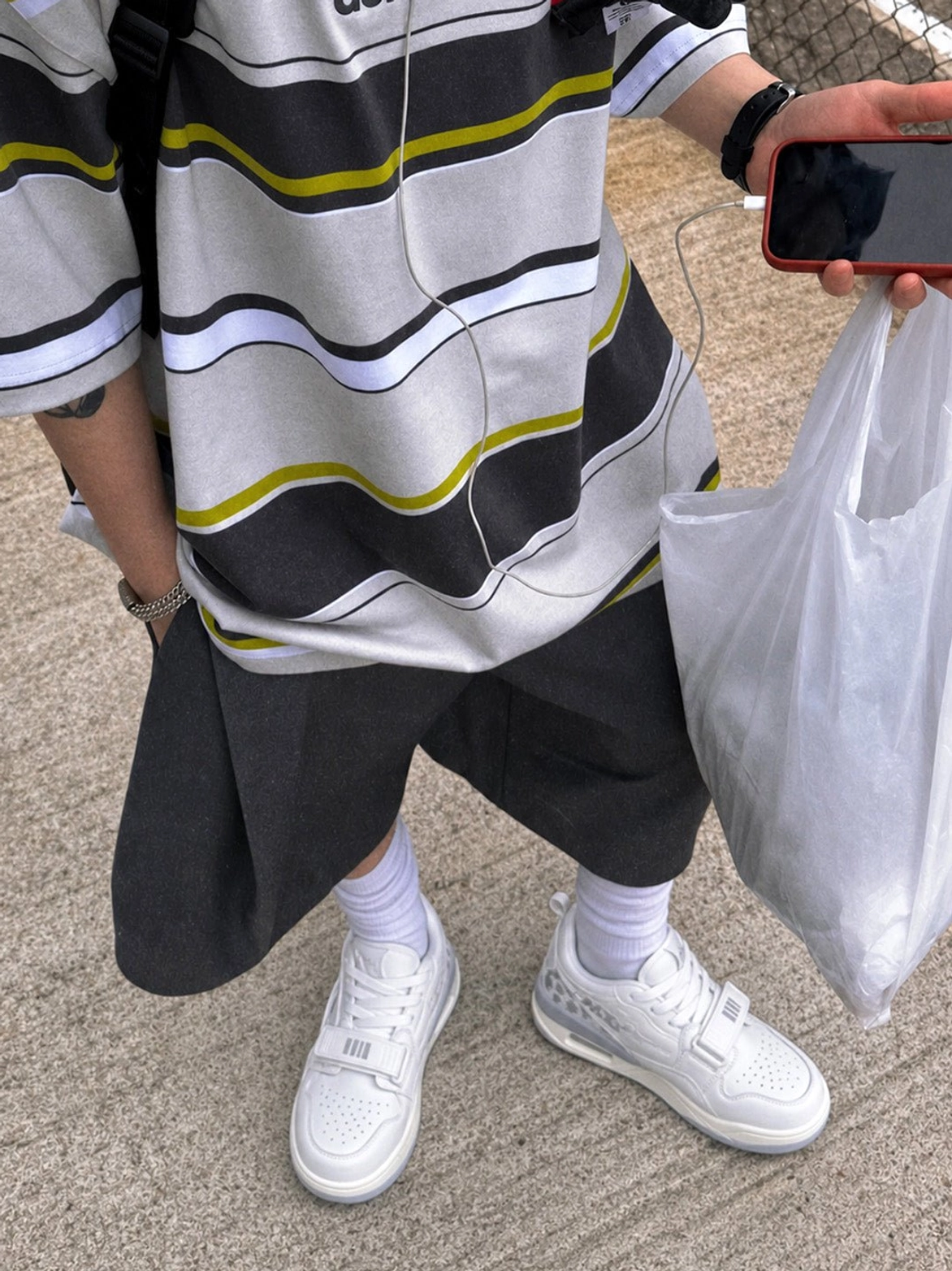 Close-up of white colorblock court sneakers worn on an urban sidewalk with chunky cushioned soles and casual streetwear styling