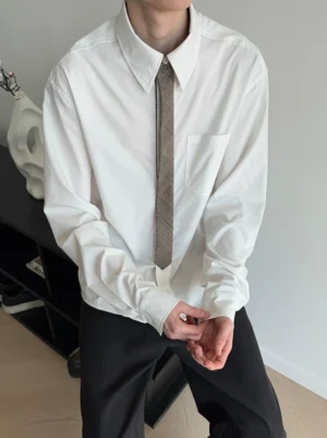 Close-up front view of a white contrast collar button-down shirt with neutral grey tie and chest pocket