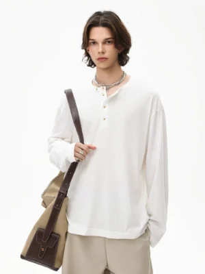 White cotton Henley long sleeve tee styled with beige loose trousers and a brown leather crossbody bag in relaxed Korean streetwear fashion