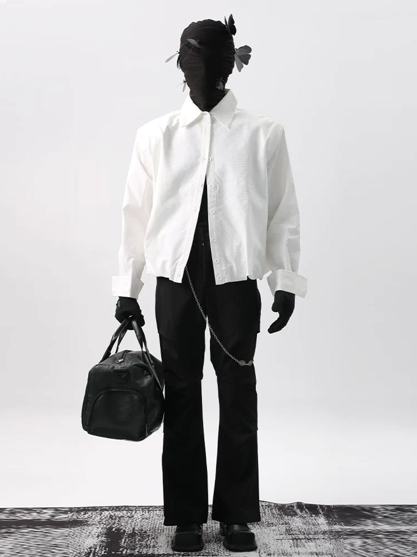 White cropped cotton poplin shirt with point collar styled with black flared trousers and waist chain for Seoul fashion