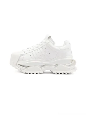 White cutout platform sneakers shown from a side overhead view with layered tonal panels, rounded shell toe, lace-up front, and chunky split-style outsole