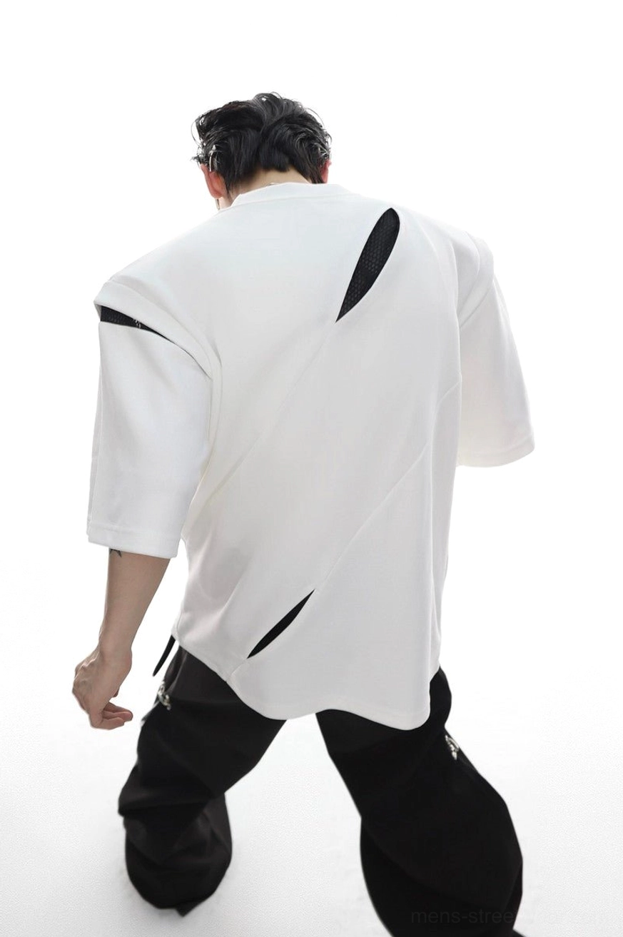Back view of white oversized deconstructed streetwear tee with multiple diagonal black mesh cutouts asymmetric seams and padded shoulders