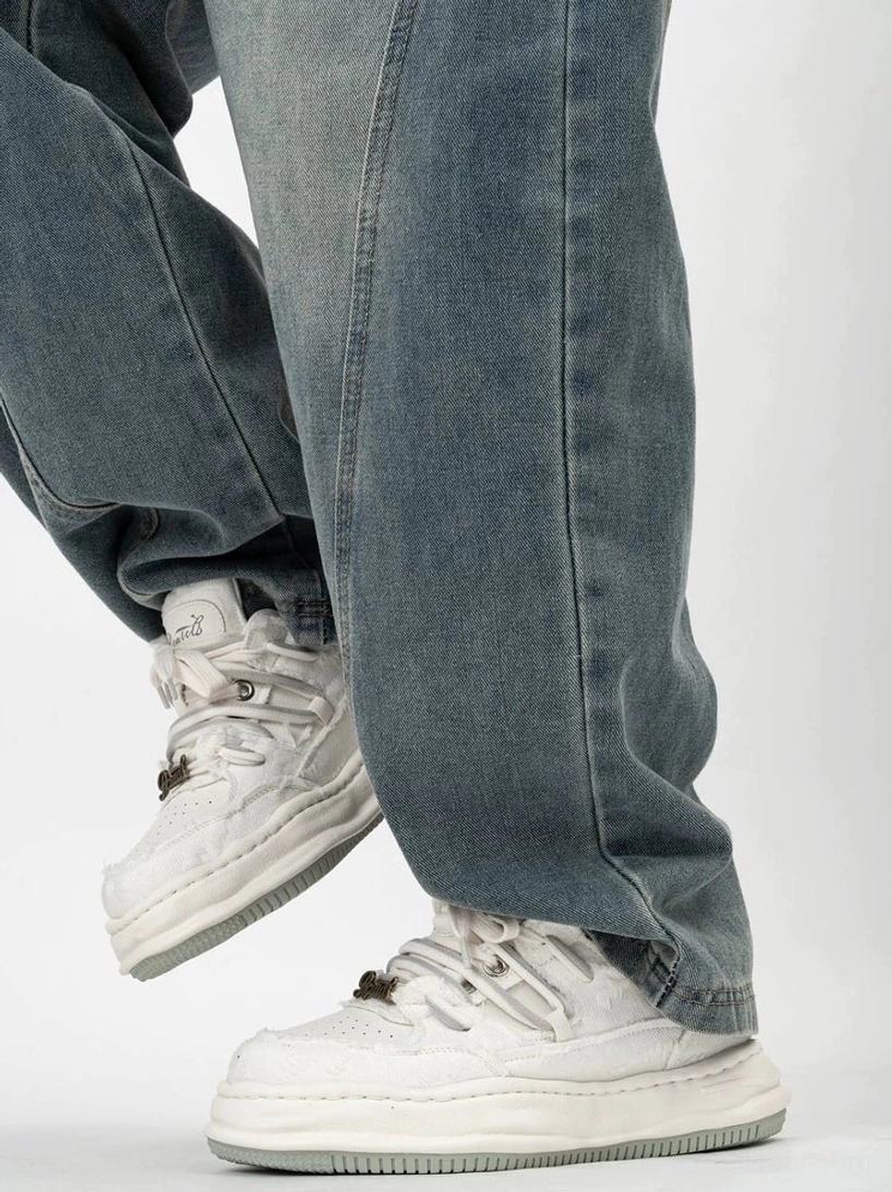 White distressed chunky platform sneakers shown from the rear on foot with dissolved-style thick sole and padded low-top collar