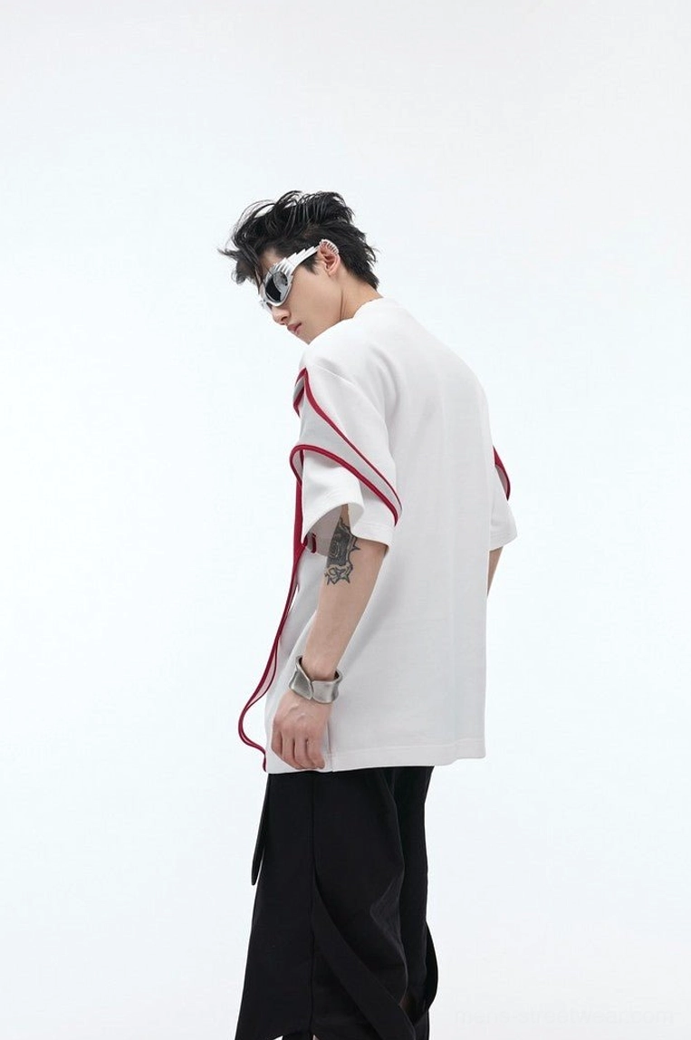 Back view of white double layer deconstructed oversized t-shirt with red sleeve trim styled with black wide leg streetwear pants