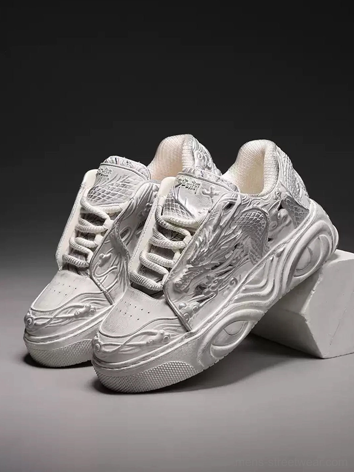 Pair of white dragon relief platform sneakers displayed together with matching embossed uppers and sculpted platform soles