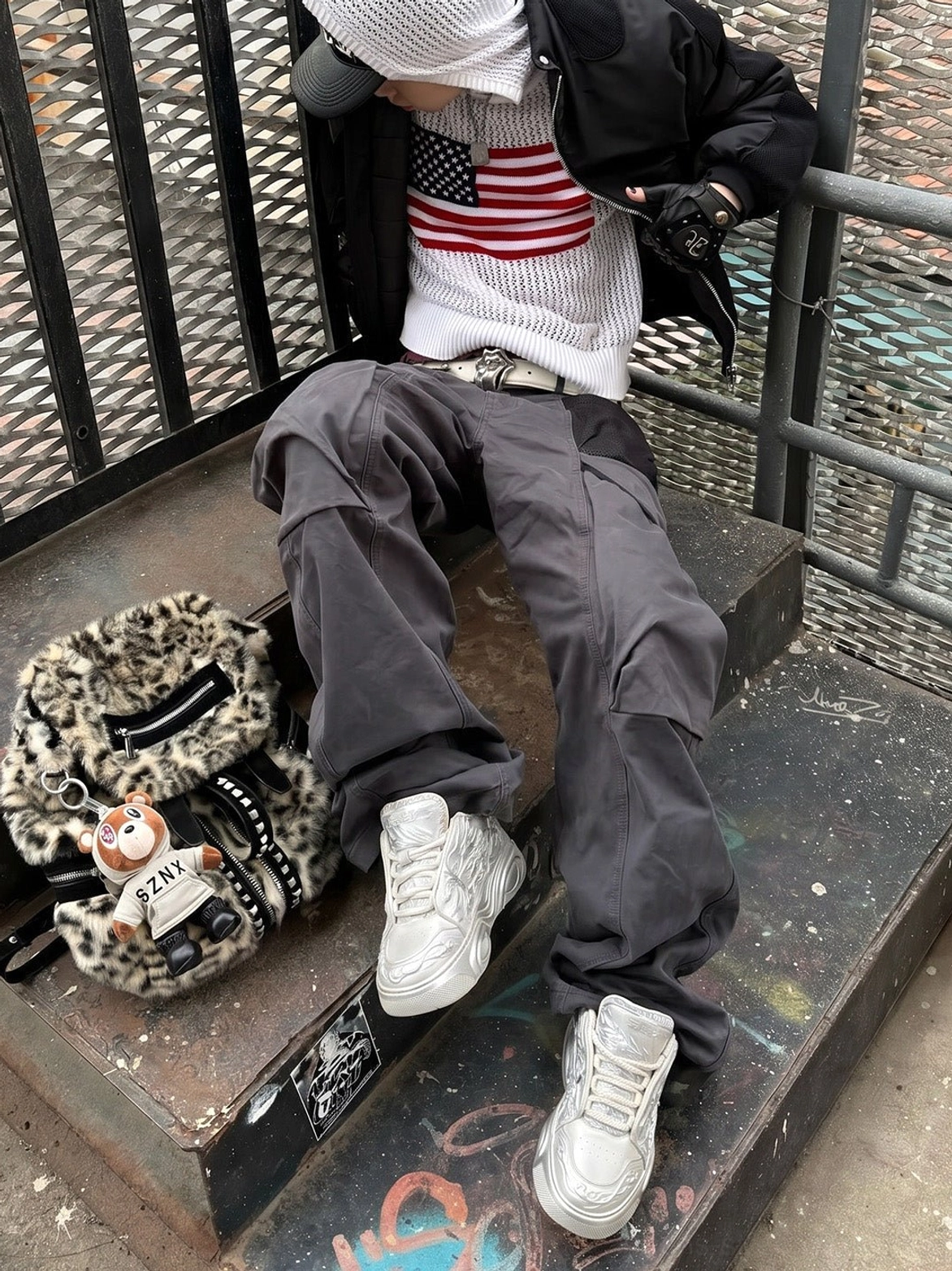 White dragon relief platform sneakers styled with loose cargo pants in an industrial Seoul-inspired streetwear stairwell