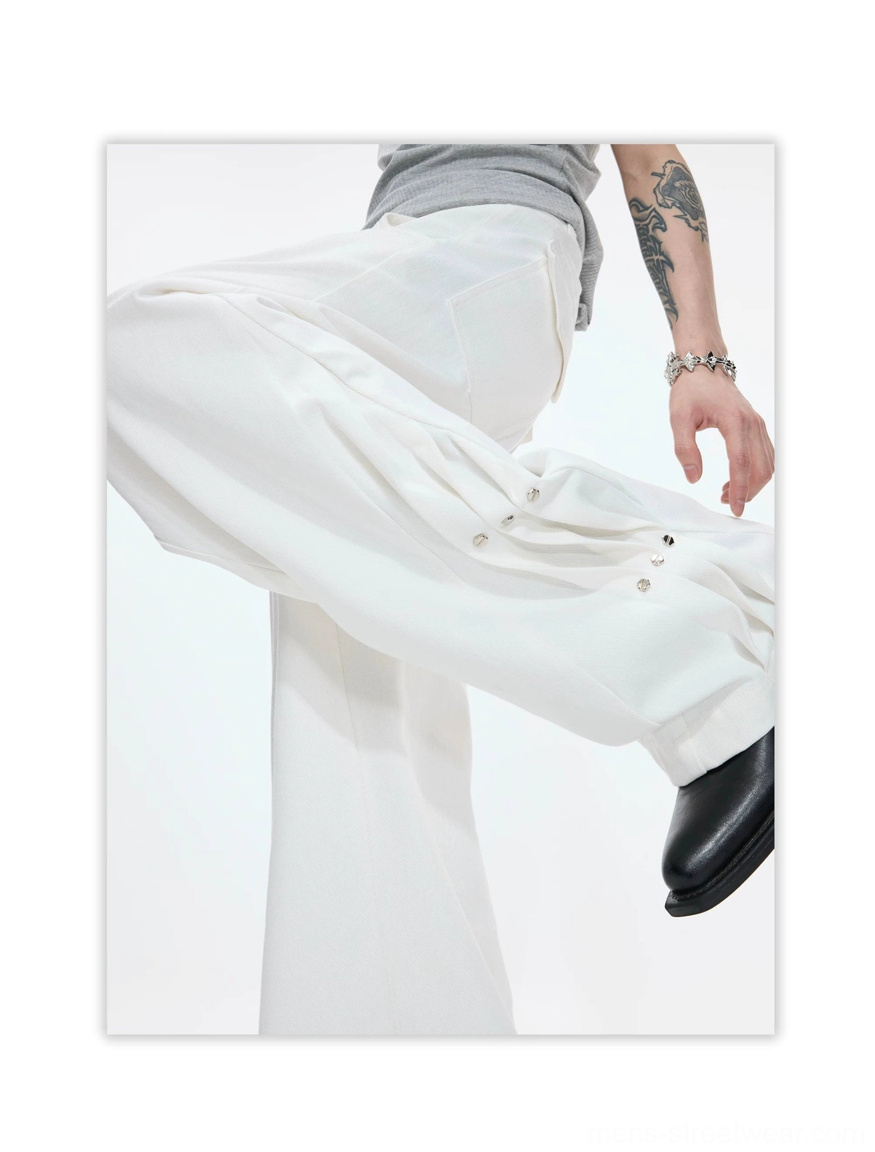 White draped wide leg cotton pants in a dynamic side pose showing fluid fabric movement and adjustable snap-button hems