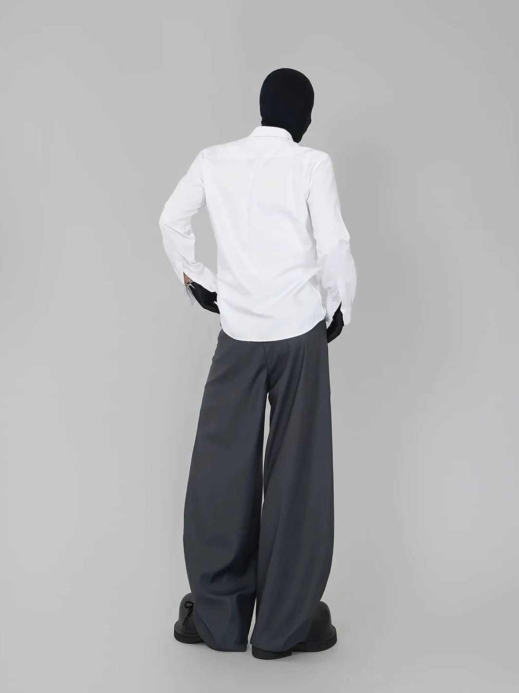 Back view of a white long-sleeve dress shirt styled with high-waisted wide-leg gray suit trousers