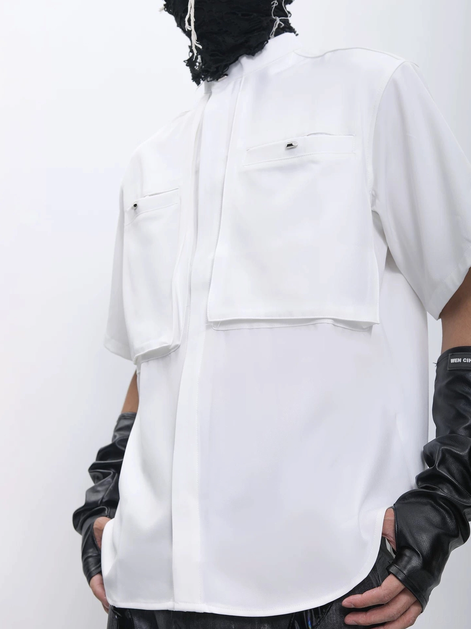 White dual-pocket stand collar utility shirt rear three-quarter view showing smooth structured woven fabric