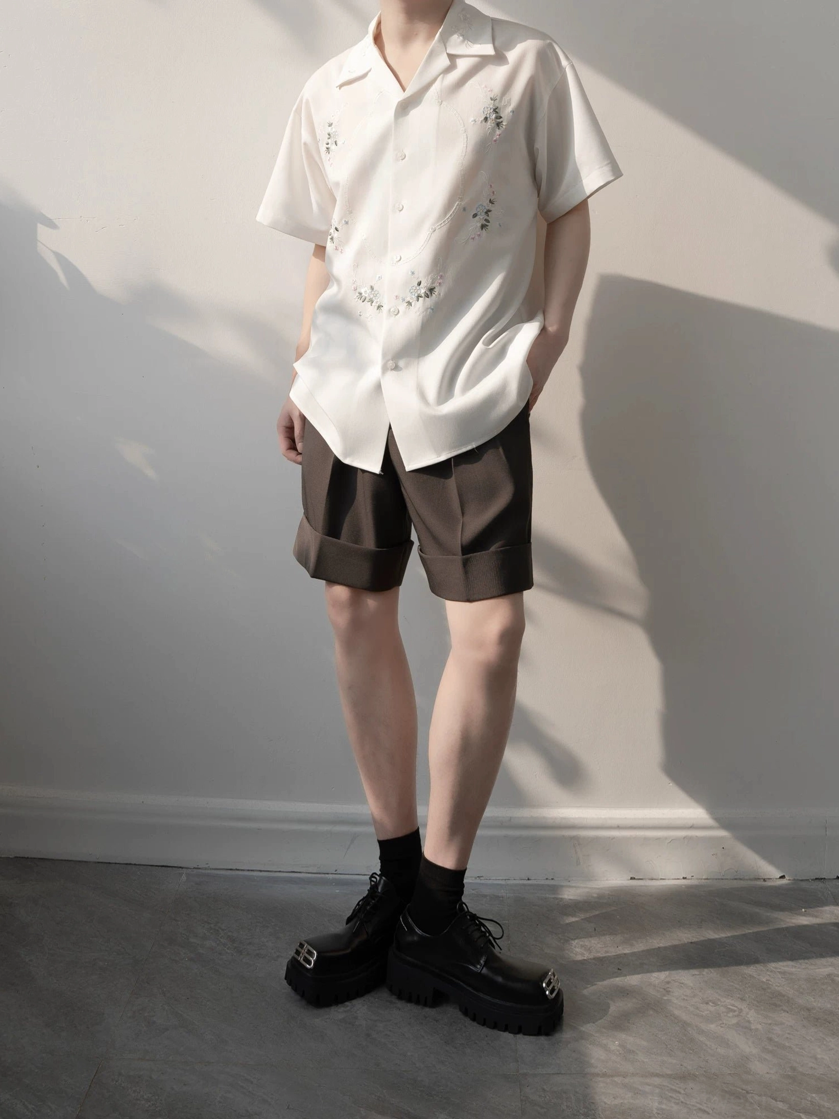 White embroidered camp collar shirt paired with brown rolled hem shorts in a contemporary Seoul streetwear outfit