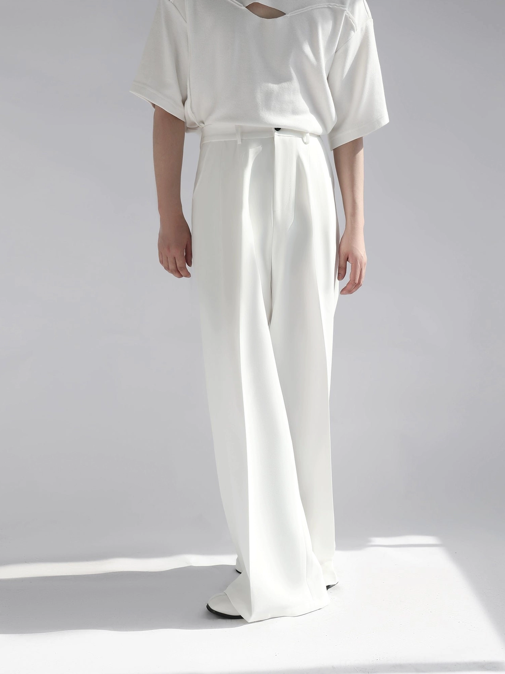 White floor-length wide leg trousers front standing view with clean button waist and tailored silhouette