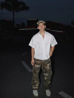 White floral eyelet oversized short sleeve shirt styled with camouflage cargo pants and casual sneakers